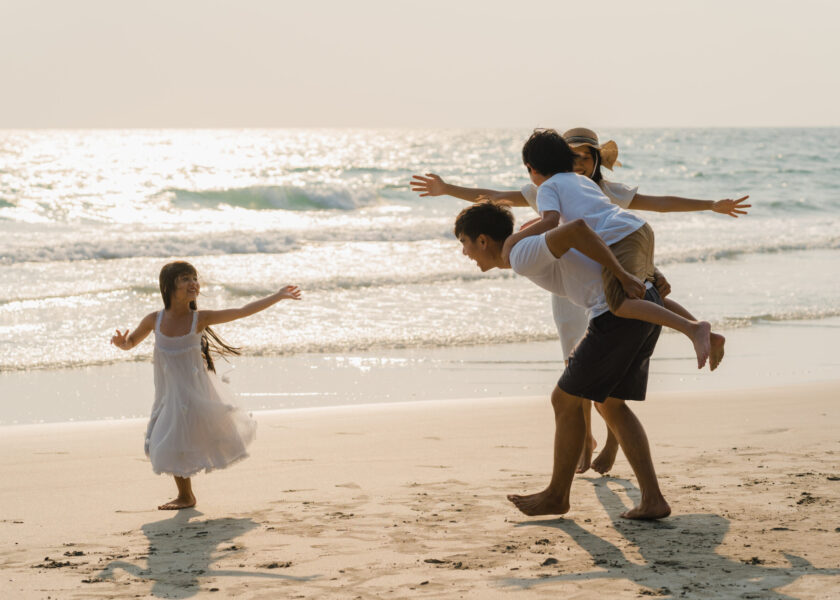 Asian young happy family enjoy vacation on beach in the evening.